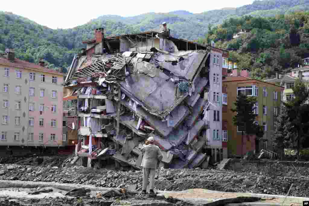 A man looks at destroyed building, in Bozkurt town of Kastamonu province, Turkey, Aug. 14, 2021. The death toll from severe floods and mudslides in coastal Turkey has climbed to at least 44, the country's emergency and disaster agency said.