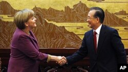 German Chancellor Angela Merkel (L) shakes hands with Chinese Premier Wen Jiabao before a news conference in the Great Hall of the People in Beijing, February 2, 2012.