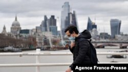 A pedestrian uses Waterloo Bridge to cross over the River Thames, backdropped by skyscrapers and offices of London on Jan. 29, 2022.