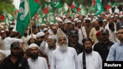 FILE - Sunni cleric Maulana Ahmed Ludhianvi, center, leader of Ahl-e-Sunnat Wal Jamaat (ASWJ), a political and religious group, leads a protest rally in Islamabad, Aug. 22, 2014.