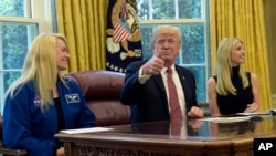 El presidente de EE.UU., Donald Trump, flanqueado por la astronauta de la NASA Kate Rubins (izquierda) y por su hija Ivanka Trump, llamó vía video conferencia a la Estación Espacial Internacional el lunes, 24 de abril de 2017.