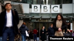 FILE - Pedestrians walk past a BBC logo at Broadcasting House, London. A BBC correspondent in China, John Sudworth, has been relocated to Taiwan amid concerns for his safety and that of his family.