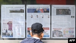 A man looks at a newspaper displayed in Seoul on Oct. 21, 2024, with coverage on North Korea's decision to deploy thousands of soldiers to Ukraine's front lines.