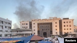 FILE —Smoke rises as displaced Palestinians take shelter at Al Shifa hospital, amid the ongoing conflict between Hamas and Israel, in Gaza City, November 8, 2023.