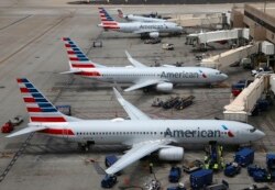 FILE - American Airlines planes arrive at Phoenix Sky Harbor International Airport in Phoenix, July 17, 2019.