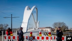German police officers guard a closed bridge at the French-German border at the river Rhine in Kehl, Germany, March 16, 2020. German government allows only restricted access from France to Germany.