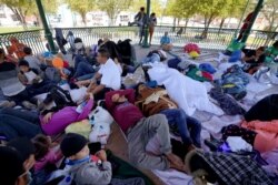 Migrants rest on a gazebo at a park after they were expelled from the U.S. and pushed by Mexican authorities off an area where they had been staying, in Reynosa, Mexico, March 20, 2021.