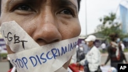 In this photo taken on Nov. 16, 2012, a Cambodian protester tapes his mouth shut in protest against discrimination of the Lesbian, Gay, Bisexual and Transgender (LGBT), in front of National Assembly, in Phnom Penh, Cambodia. 