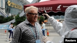 A man gets his temperature checked before entering the Canton Fair, China’s largest trade show in Guangzhou, October 23, 2014. (Reuters)