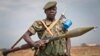 A South Sudanese government soldier stands guard as a delegation of visiting officials leaves from the airport in Malakal, Upper Nile State, in South Sudan, Jan. 21, 2014.