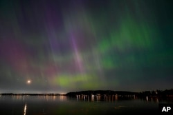 FILE - The northern lights, or aurora borealis, are visible over Lake Washington, in Renton, Wash., May 10, 2024.