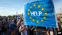 FILE - Supporters of Hungary's political opposition display a banner during an anti-government protest in Budapest, Hungary, May 21, 2017.﻿ Protesters are calling on the government to repeal legal amendments seen as representing a departure from Western civil society principles.