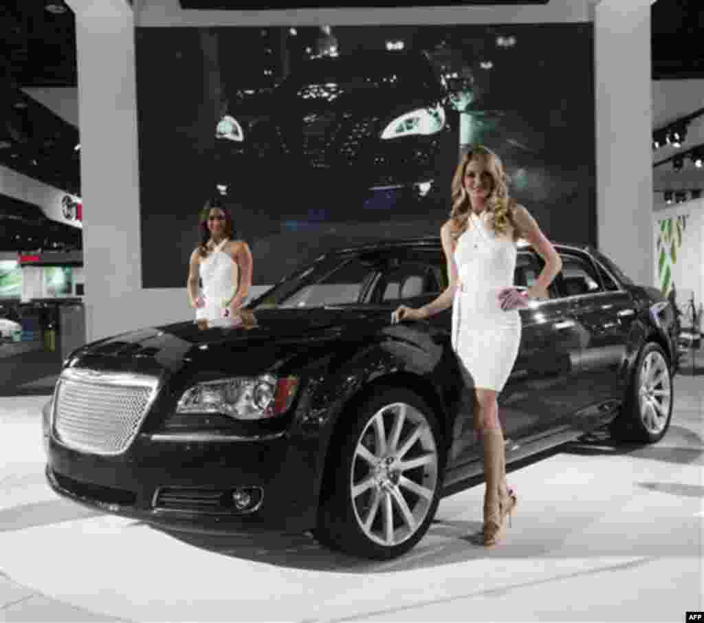 Models pose with the new Chrysler 300 at the North American International Auto Show in Detroit, Tuesday, Jan. 11, 2011. (AP Photo/Paul Sancya)