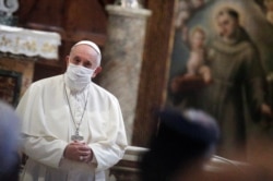 FILE - Pope Francis wears a face mask as he attends an inter-religious prayer service for peace in the Basilica of Santa Maria in Aracoeli, a church on top of Rome's Capitoline Hill, in Rome, Italy, Oct. 20, 2020.