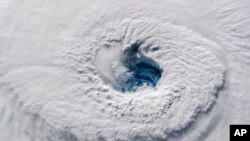 In this Sept. 12, 2018 photo provided by NASA, Hurricane Florence churns over the Atlantic Ocean heading for the U.S. east coast as seen from the International Space Station. Astronaut Alexander Gerst, who shot the photo, tweeted: "Ever stared down the gaping eye of a category 4 hurricane? It's chilling, even from space." (Alexander Gerst/ESA/NASA via AP)