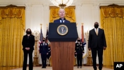 President Joe Biden speaks during an event to mark International Women's Day, Monday, March 8, 2021, in the East Room of the White House in Washington, as Vice President Kamala Harris and Defense Secretary Lloyd Austin listen. (AP Photo/Patrick…