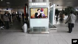 A TV screen shows South Korean President Lee Myung-bak's panel discussion at Seoul Railway Station in Seoul, South Korea, February 1, 2011