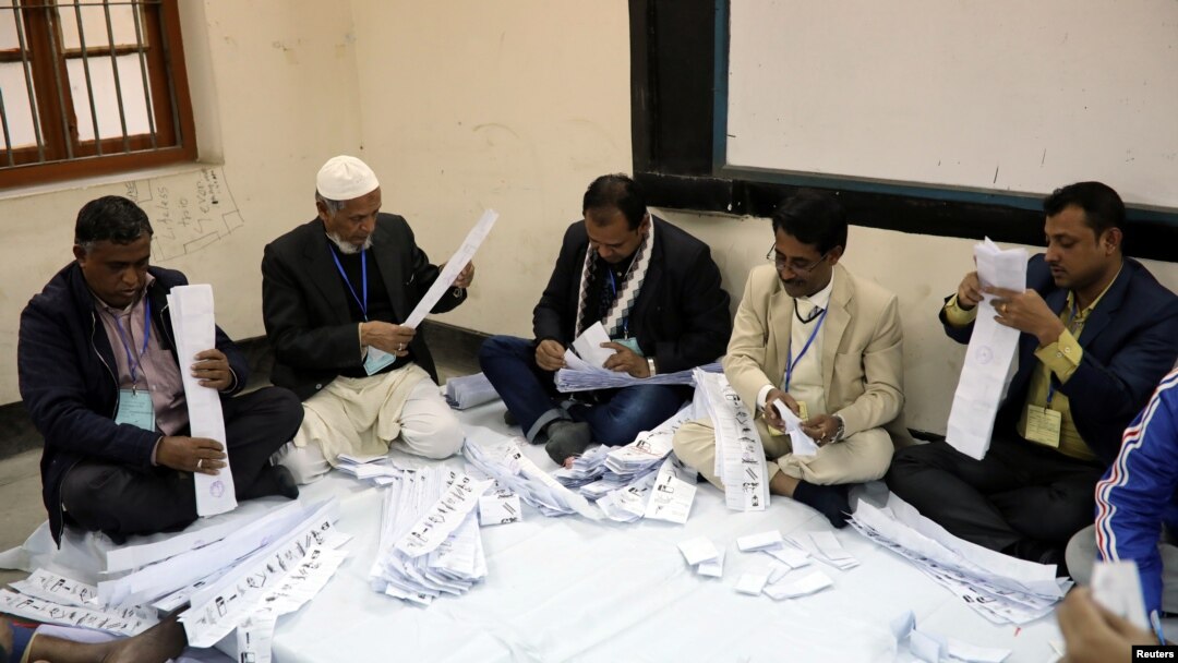 Para anggota pengawas pemilu sedang menghitung surat suara di pusat pemungutan suara di Dhaka, Bangladesh, 30 Desember 2018. 