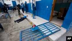 A guard lies dead inside the Civil Prison after a jail break in the coastal town of Arcahaiea, Haiti, Oct. 22, 2016. 