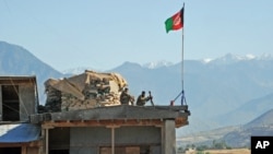 FILE - Two Afghan soldiers sit on a guard tower at a military base in Nari district, Kunar province, Afghanistan. 