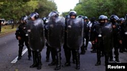 Anti-riot police observe workers participating in a roadblock at the International Airport highway as a protest against the Salvadorian government in Olocuilta, November 7, 2016. On November 8, 2016, El Salvador lost two more security officers to gang attacks.