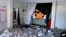 FILE - Pakistani children play next to the picture of Altaf Hussain, a top leader of Muttahida Qaumi Movement, or MQM, at one of his party offices demolished by authorities in Karachi Pakistan, Tuesday, Sept. 6, 2016. 