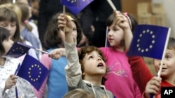 FILE - Bosnian children wave European Union flags at a celebration of European Day in the Bosnian capital Sarajevo, May 9, 2007.