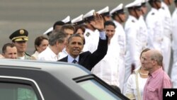 Prezidan Barack Obama ap salye foul la pandan li rive nan Katajèn. A dwat li, ambasadè ameriken an nan Kolonbi, Michael McKinley.