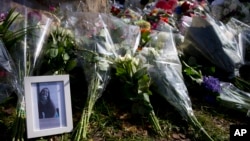 A picture of one of the three victims sits amidst flowers as mourners pay their respect at the site of a shooting incident in a tram in Utrecht, Netherlands, March 19, 2019.
