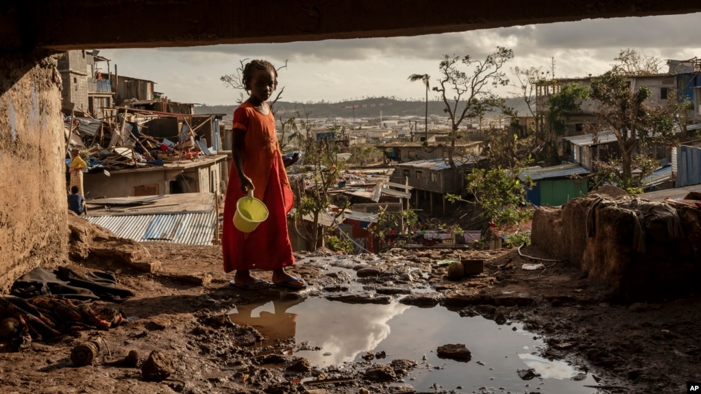 A young girl walks in the Kaweni slum on the outskirts of Mamoudzou, in the French Indian Ocean island of Mayotte, Thursday, Dec. 19, 2024, after Cyclone Chido. (AP Photo/Adrienne Surprenant)