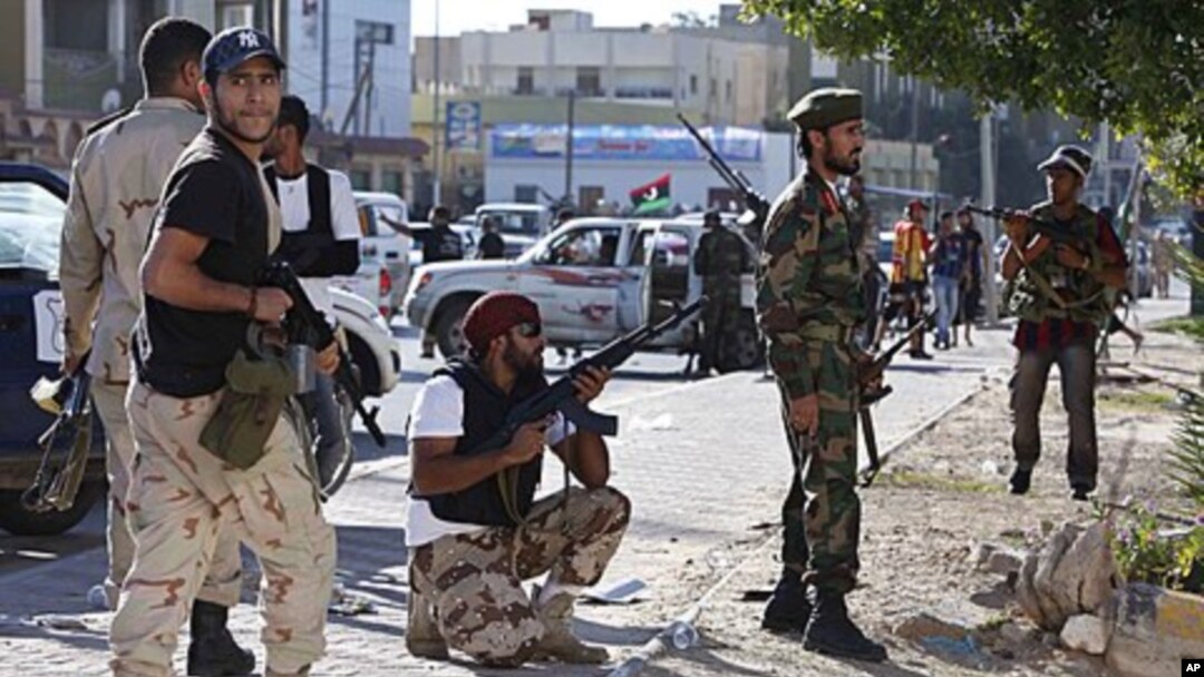 Anti-Gaddafi fighters take position during a gun battle with pro-Gaddafi's supporters in the Abu Salim neighborhood in Tripoli, Libya, October 14, 2011.