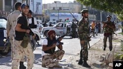 Anti-Gaddafi fighters take position during a gun battle with pro-Gaddafi's supporters in the Abu Salim neighborhood in Tripoli, Libya, October 14, 2011.