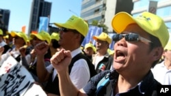 Taiwanese workers shout slogans during a protest in Taipei, Taiwan, Jan. 4, 2020. Hundreds of workers from various labor groups staged a protest before general elections demanding for better conditions for workers. 