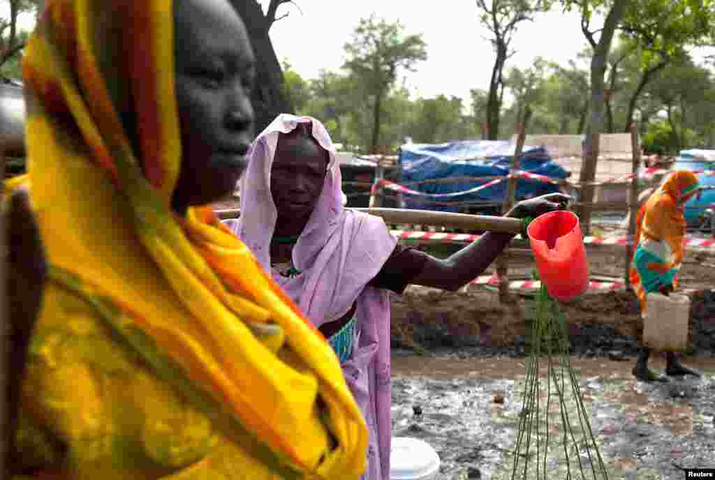Women gather to collect water at the Yusuf Batil refugee camp in Upper Nile, South Sudan, July 4, 2012.