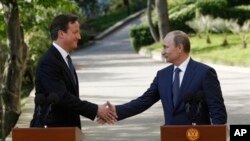 PM Inggris David Cameron dan Presiden Rusia Vladimir Putinsaling berjabat tangan usai pertemuan mereka di sebuah tempat peristirahatan di kota Sochi, Russia (10/5).