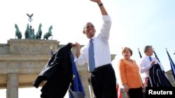 Predsednik Obama maše okupljenima ispred Brandenburške kapije gde je danas održao govor, 19. juni, 2013. 