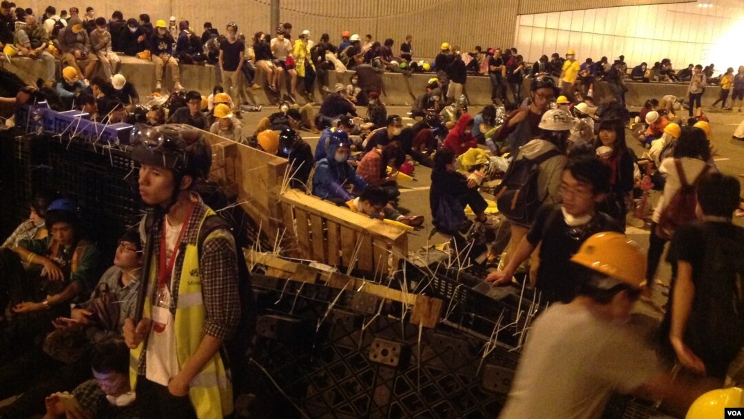 Para demonstran Hong Kong memblokir lalu lintas di sebuah jalan utama, Minggu (30/11).
