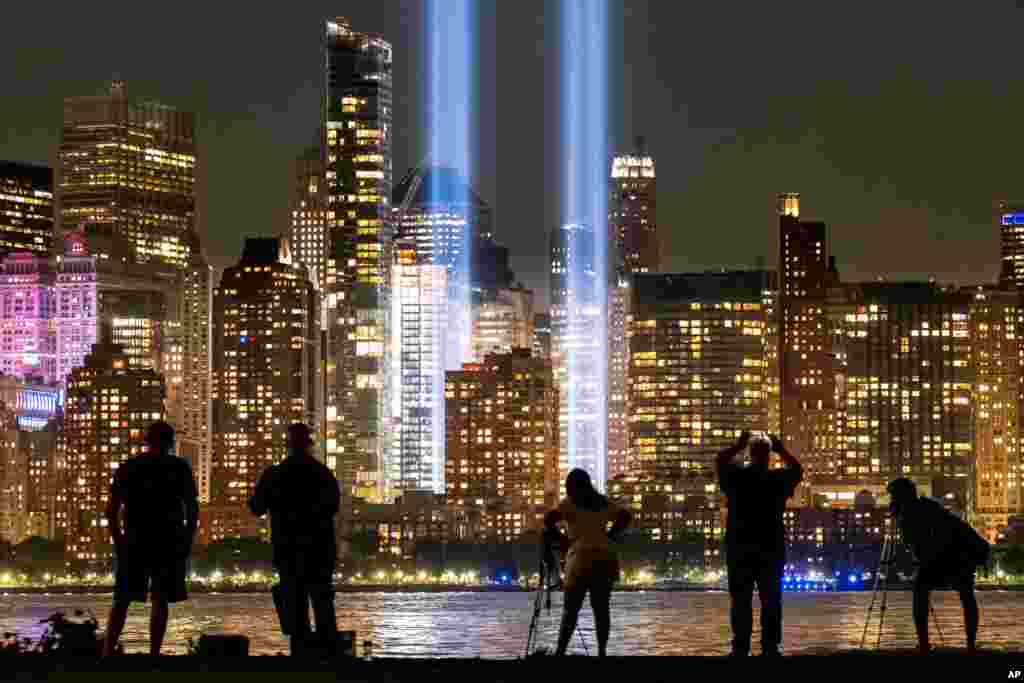 Spectators and photographers look at the Sept. 11 tribute lights in New York City across from the Hudson River from Jersey City, New Jersey, Sept. 11, 2019, on the 18th anniversary of the attacks on the twin towers of the World Trade Center.
