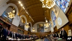 Judges, right, enter the World Court in The Hague, March 6, 2017, where Ukraine, left, is taking Russia, rear center, to the United Nations' highest judicial organ, accusing Moscow of financing separatist rebels and racially discriminating against ethnic Tartars and Ukrainians in the annexed Crimea peninsula. 