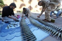 FILE - Fighters from a Misrata armed group loyal to the Libyan Government of National Accord (GNA) prepare their ammunition as battles against Forces of Libyan strongman Khalifa Haftar continue on the outskirts of the capital Tripoli, April 9, 2019.