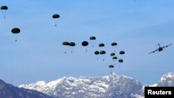 FILE - A U.S. Air Force C-17 Globemaster III from the 97th Air Mobility Wing plane drops paratroopers during an exercise over the NATO airbase in Aviano, Italy.