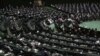 FILE - Participants listen to a speaker during the swearing-in ceremony of Iranian President Ebrahim Raisi at the parliament in Tehran, Iran, Aug. 5, 2021. 