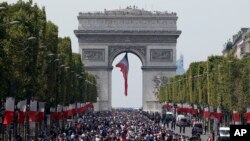 The crowd gathers to welcome the French soccer team for a parade a day after the French team victory in the soccer World Cup, July 16, 2018 in Paris. 