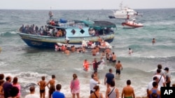 Para turis membantu penjaga pantai Italia menyelamatkan para migran Eritrea (foto: dok).