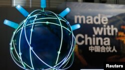 FILE - The motto of the 2015 CeBit trade fair ' Made With China' is seen next to a rotating globe at the IBM booth during the fair in Hanover, Germany, March 16, 2015. 
