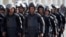 FILE - Riot police take their positions outside a police academy, where ousted Egyptian President Mohamed Mursi's second trial session was due to take place, on the outskirts of Cairo January 8, 2014. 