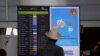 FILE - A man checks departure information on a display screen at Faro airport amid the coronavirus disease (COVID-19) pandemic, in Faro, Portugal, June 6, 2021. 