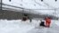 In this image taken from video provided by Lars Mlekusch, a bulldozer clears snow on a road in Zermatt, Switzerland, Jan. 9, 2018.