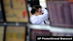 A currency trader watches monitors at the foreign exchange dealing room in Seoul, South Korea, March 27, 2017