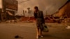 A man walks past a fire-ravaged business after the Eaton Fire swept through Altadena, California, Jan. 8, 2025.